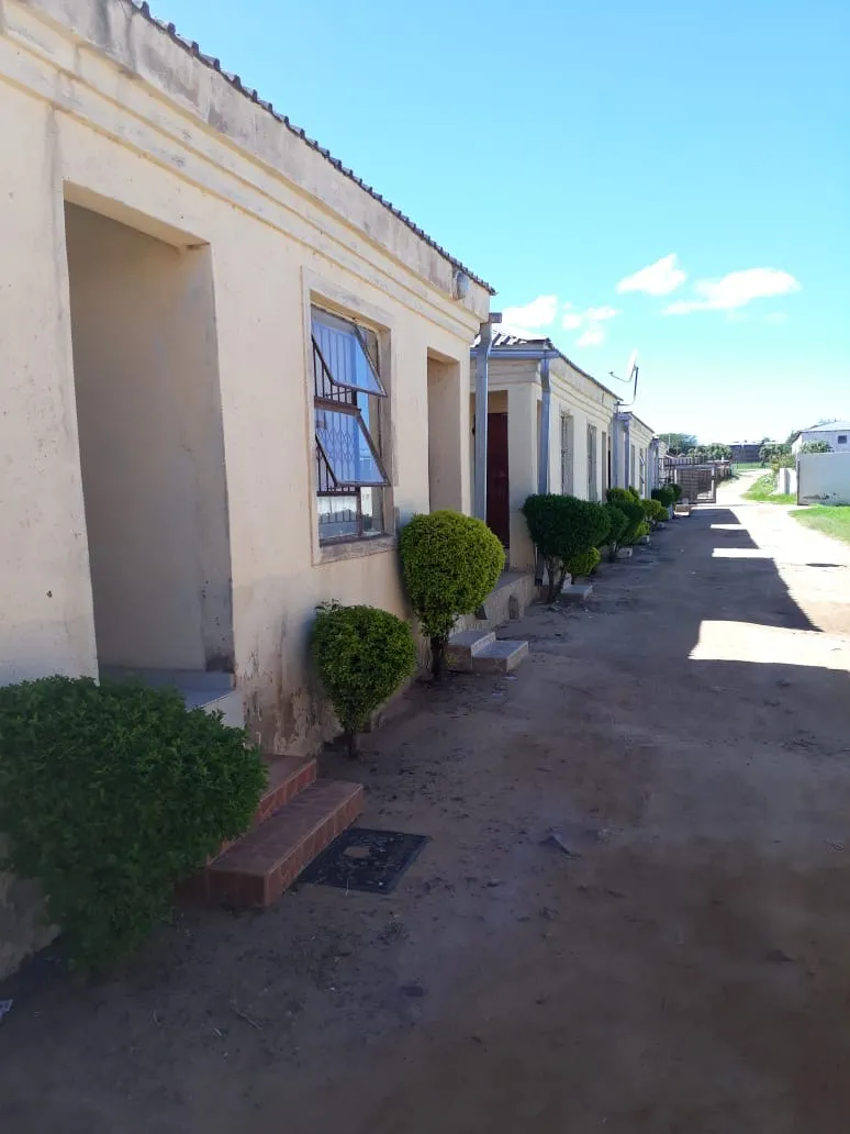 Room entrances at Eribuweni Gardens with trimmed garden shrubs and tiled steps